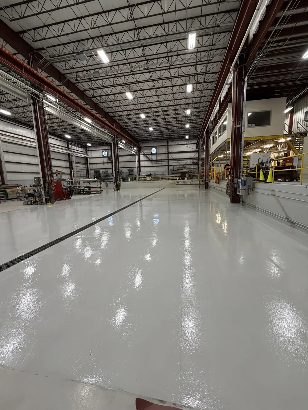 Solid color epoxy floor down the length of an industrial plant bay
